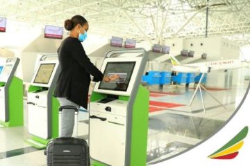 Person using self-service kiosk at airport.
